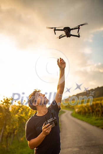 Young man flying a drone in warm evening sunlight Young man flying a drone in warm evening sunlight