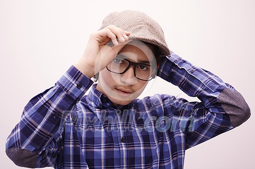 portrait  of smart looking arab teenager with glasses wearing a hat in casual school look isolated on white copy space