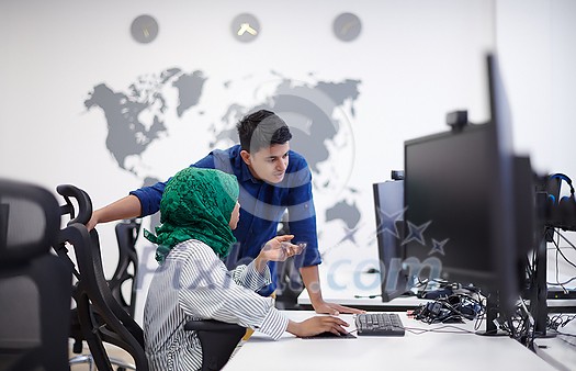 Multiethnic startup business team Arabian woman wearing a hijab on meeting in modern open plan office interior brainstorming, working on laptop and desktop computer