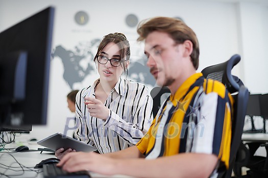 business couple working together on project using tablet and desktop computer at modern open plan startup office