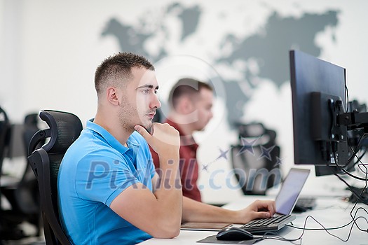 startup business, two male software developers working on computer at new modern open plan office startup business, two male software developers working on computer at new modern open plan office