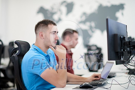 startup business, two male software developers working on computer at new modern open plan office