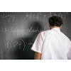 Senior math teacher teaching mathematics, writing on the blackboard during class