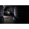 Inside a garage - modern car waiting for the mechanic to change its wheels/tires (shallow DOF; color toned image)