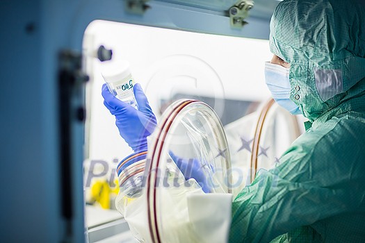 Virus antidote being prepared in a biochem lab with extremely strict precautionary measures (shallow DOF; color toned image) Virus antidote being prepared in a biochem lab with extremely strict precautionary measures (shallow DOF; color toned image)