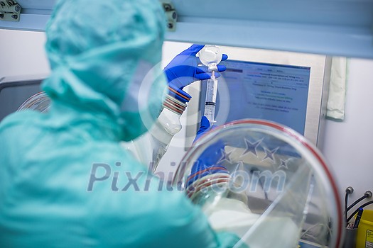 Virus antidote being prepared in a biochem lab with extremely strict precautionary measures (shallow DOF; color toned image) Virus antidote being prepared in a biochem lab with extremely strict precautionary measures (shallow DOF; color toned image)