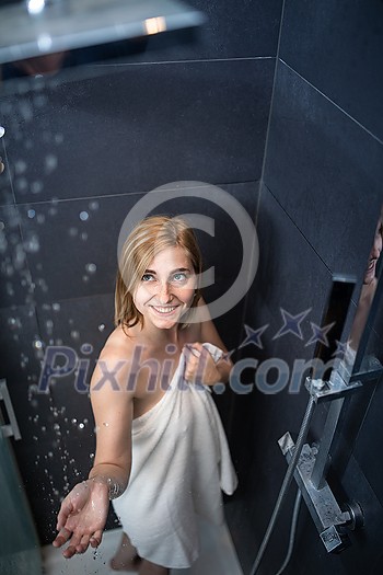 Pretty, young woman taking a long hot shower washing her hair in a modern design bathroom Pretty, young woman taking a long hot shower washing her hair in a modern design bathroom