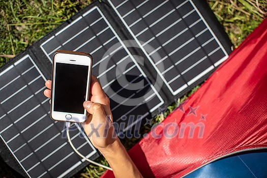 Cell phone charging with a solar charger in a tent during an outdoor trip Cell phone charging with a solar charger in a tent during an outdoor trip