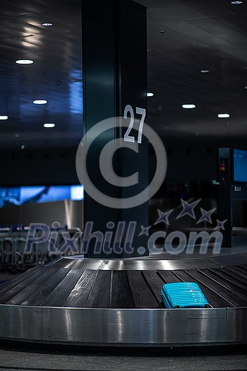 Luggage on a conveyor belt international airport, at the baggage claim zone - motion blurred image