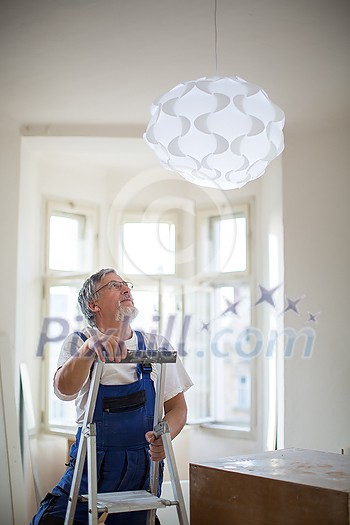 DIY, repair, building and home concept - Senior landlord hanging a new light in a rental appartement (shallow DOF; color toned image) DIY, repair, building and home concept - Senior landlord hanging a new light in a rental appartement (shallow DOF; color toned image)