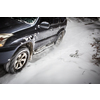 Motion blurred image of a big suv car going fast on a snow covered forest road