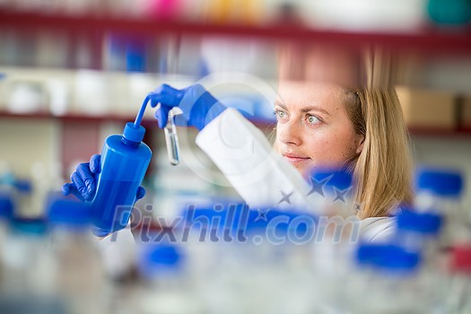 Portrait of a female researcher doing research in a lab (shallow DOF; color toned image)