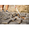 Blind woman walking on city streets, using her white cane to navigate the urban space better and to get to her destination safely