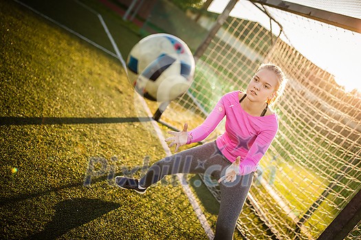 Teen female goalie catching a shot during a soccer game