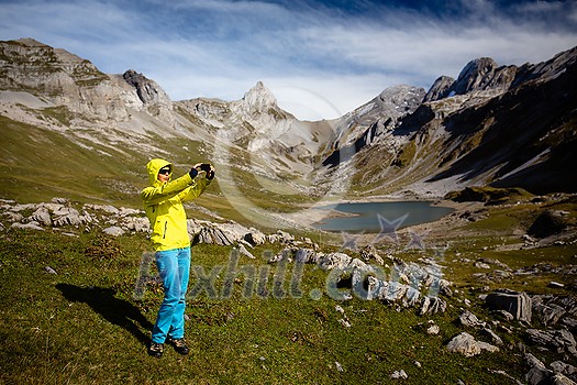 Pretty, young female hiker walking in high mountains (shallow DOF)