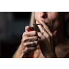 Mid-aged woman lighting a cigarette at home, getting her nicotine daily dose, unable to resist to her unhealthy habit