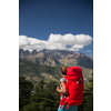 Pretty, female hiker in high mountains packing her backpack