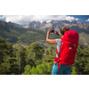 Pretty, female hiker in high mountains packing her backpack