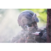 modern warfare soldier in action aiming at weapon  laser sight optics  in combat position while searching for a target in battle