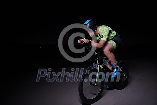 triathlon athlete cycling fast riding professional racing bike at night