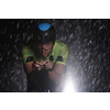 triathlon athlete riding professional racing bike fast  at night with bad weather and falling rain