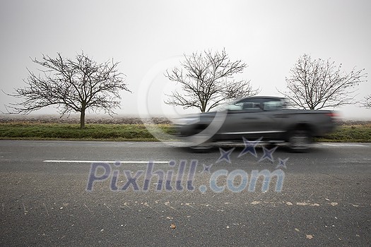 Motion blurred truck going fast on a rural road Motion blurred truck going fast on a rural road
