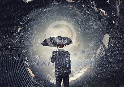 Back view of businessman with umbrella looking at city Back view of businessman with umbrella looking at city