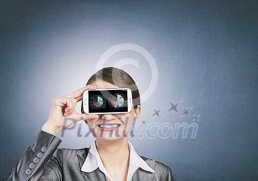 Beautiful young woman holding mobile phone against her eyes Beautiful young woman holding mobile phone against her eyes