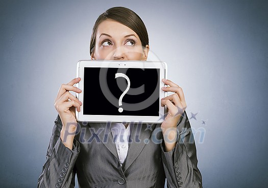 Beautiful young woman holding tablet with question against her mouth