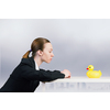 Young businesswoman and yellow rubber duck toy on table