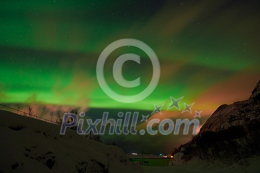 Aurora borealis Green northern lights above mountains on the Lofoten islands, Norway. Night sky with polar lights. Night winter landscape with aurora.
