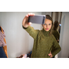 Young woman shopping in a fashion store, trying on some clothes she likes (color toned image; shallow DOF)