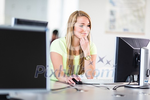 Pretty, female student looking at a desktop computer screen, learning unpleasant news about her exam results. University/office/school concept