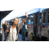 Pretty young woman boarding a train/having arrived to her destination, waiting for her friends to pick her up (color toned image)