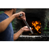 Cook baking pizza in a traditional stone wood fired oven