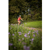 Pretty, young woman riding her mountain bike on a forest path. Enjoying active leisure time outdoors.