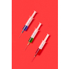 Medical set of sterile plastic disposable syrenges 20 ml with colorful vaccines or serum for an intravenous injection on a red background with soft shadow, copy space. Top view.