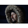 portrait local authentic eskimo  man at winter in stormy weather wearing warm  fur jacket in northern cold night