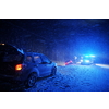 car accident on slippery winter road at night with heavy snow fall and paramedic ambulance first aid car