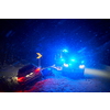 car accident on slippery winter road at night with heavy snow fall and paramedic ambulance first aid car