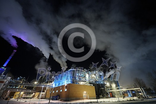 Factory at Night Atmospheric Environmental Air Pollution From Industrial Smoke. Pipes Steel Tank Plant Wood and Paper Production. Thick Smoke and Steam. Factory at Night Atmospheric Environmental Air Pollution From Industrial Smoke. Pipes Steel Tank Plant Wood and Paper Production. Thick Smoke and Steam.