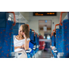 Young woman sitting in the train after a day of work . Train passenger traveling sitting relaxed and enjoying the ride