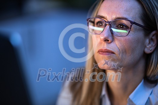 Happy stylish mid-aged woman remote working from home, staring at the computer screeen for long hours, exhausting her eyes with blue light