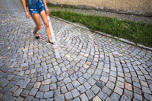 Blind woman walking on city streets, using her white cane to navigate the urban space better and to get to her destination safely Blind woman walking on city streets, using her white cane to navigate the urban space better and to get to her destination safely