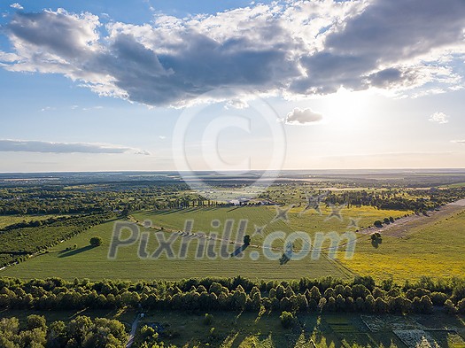 Aerial bird's eye view from drone of the outdoors picturesque landscape above farm lands, agricultural fields, and forests on bright cloudy sky background on a summer sunny day. Ukraine, Uman city. Aerial bird's eye view from drone of the outdoors picturesque landscape above farm lands, agricultural fields, and forests on bright cloudy sky background on a summer sunny day. Ukraine, Uman city.