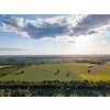 Aerial bird's eye view from drone of the outdoors picturesque landscape above farm lands, agricultural fields, and forests on bright cloudy sky background on a summer sunny day. Ukraine, Uman city.