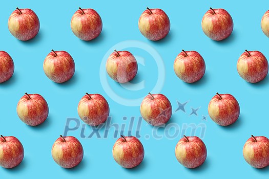 Horizontal fruits pattern from freshly picked ripe natural organic apples on a blue background with soft shadows. Vegetarian concept.