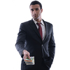 Portrait of a business man holding and catch falling money bills, isolated on white background in studio