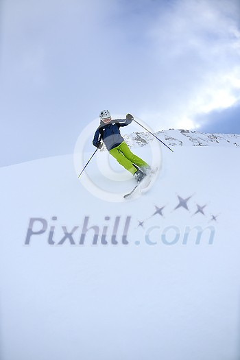 skier skiing downhill on fresh powder snow  with sun and mountains in background