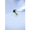 skier skiing downhill on fresh powder snow  with sun and mountains in background